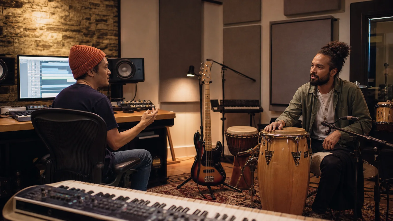 Produtor e percussionista discutindo um arranjo no estúdio
