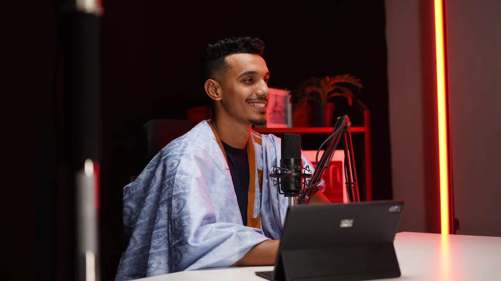 Podcast-Host nimmt mit Studiomikrofon und Laptop auf